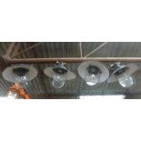 A set of four black enamelled ceiling lights with steel grills and moulded glass shades CONDITION