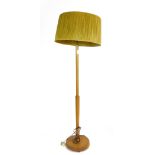 A 1970's turned teak standard lamp with a seagrass shade  CONDITION REPORT: Working order unknown