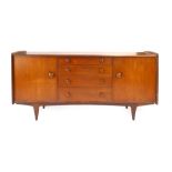 A teak sideboard with an arrangement of four drawers flanked by two doors on a sleigh type base by