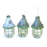 A set of three CCCP industrial ceiling lights with steel grills and moulded glass shades in pale