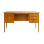 A 1970's teak desk with an arrangement of six drawers with brass handles on square straight legs, l.