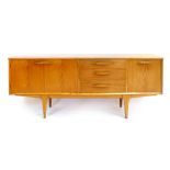 A 1960/70s teak sideboard with an arrangement of three doors and three drawers on square tapering