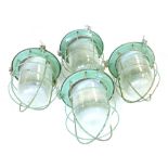 A set of four industrial bunker-type ceiling lights with steel grills and moulded glass shades