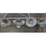 A set of four black enamelled ceiling lights with steel grills and moulded glass shades CONDITION