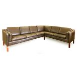 A 1970's brown leather six seater corner sofa on mahogany straight legs, in the manner of Borge