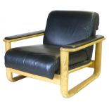 A pair of black leather armchairs with oak sleigh type frames CONDITION REPORT: Wear commensurate