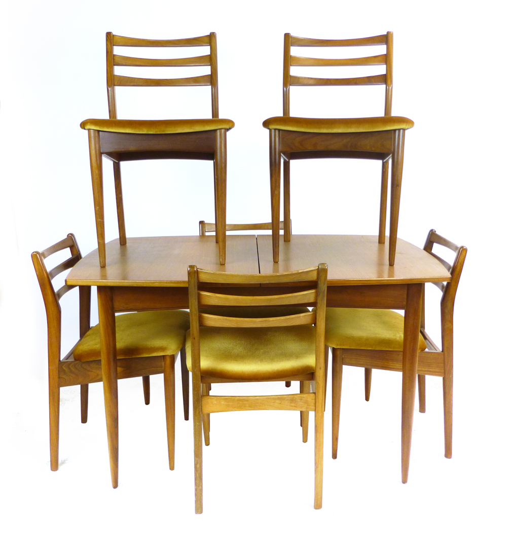 A British 1960's teak extending dining table of boat form, max l. 165 cm, together with six matching