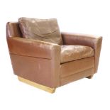 A 1970's brown leather armchair on oak sleigh type feet CONDITION REPORT: Some wear around arms