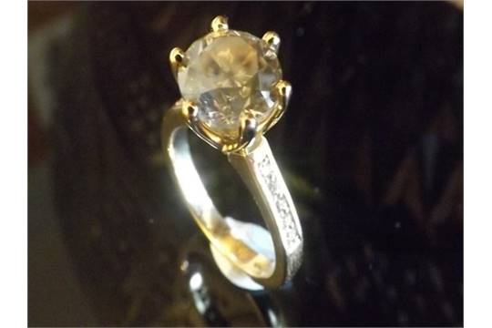 A 3 Carat DIAMOND RING claw-set and centred with a Round brilliant-cut Fancy Coloured diamond.