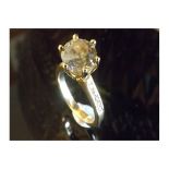 A 3 Carat DIAMOND RING claw-set and centred with a Round brilliant-cut Fancy Coloured diamond.