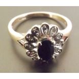 A saphire and diamond ring, A single stone sapphire ring suuround by illusion set diamonds, set in 9