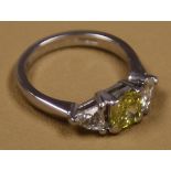 A 0.81 certified Cushion cut Yellow diamond, accomanied by a further two trillion cut diamonds set