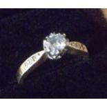 A 0.33 carat diamond solitiare ring in 18 carat gold. With futher diamonds along each shoulder