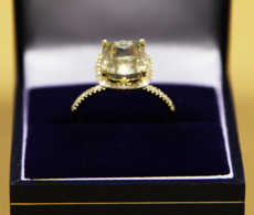 A 4.06 carat Cushion cut diamond, set in yellow gold Halo setting surrounded by diamonds.