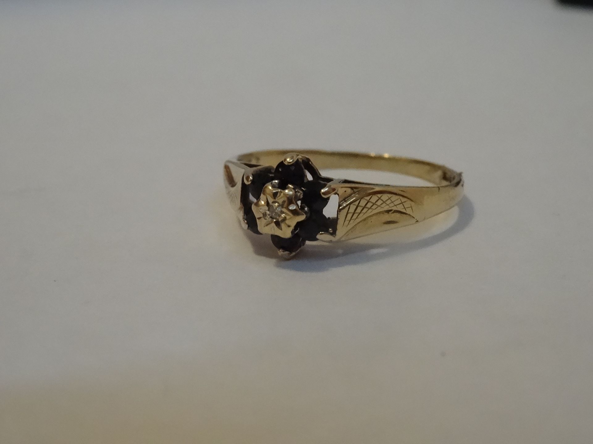 9 Carat Yellow Gold 7 Stone Diamond & Black Unchecked Stone Ring. Total Piece Weight 1.51 Grams
