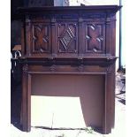 A large Jacobean revival carved oak fire place and over-mantle.