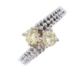 A coloured diamond two-stone crossover ring. The 'light yellow' brilliant-cut diamonds, to the