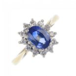 An 18ct gold sapphire and diamond cluster ring. The oval-shape sapphire, within a brilliant-cut