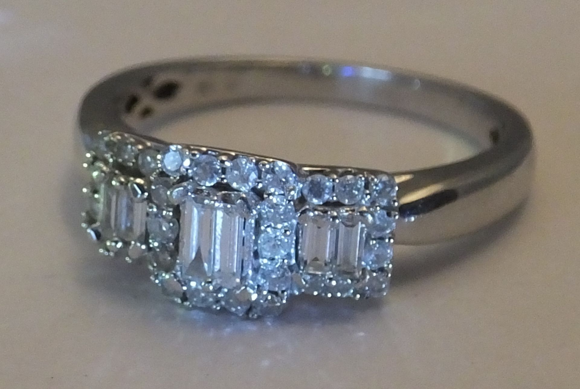 A White gold diamond ring - Size 0. Designed as two baguette-cut diamonds within a brilliant-cut