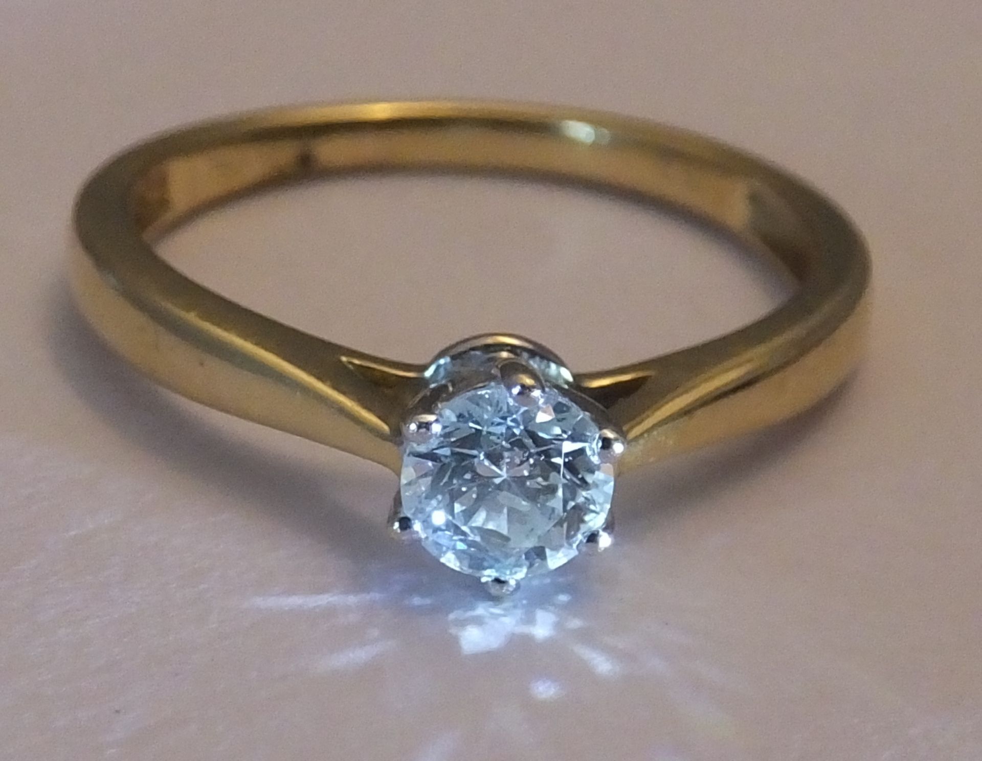 An 18ct gold diamond single-stone ring. The brilliant-cut diamond, to the plain band.