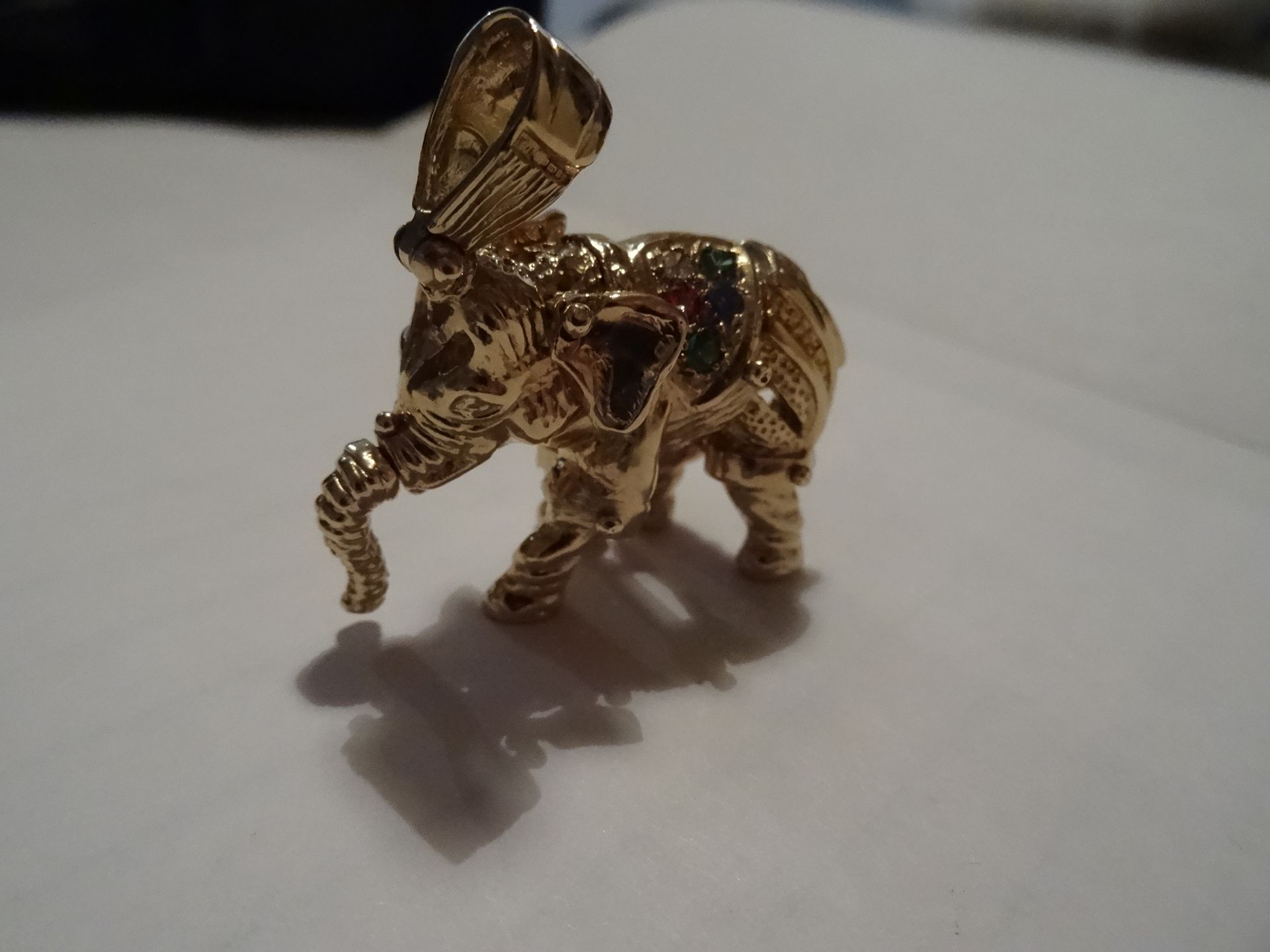 9 CARAT YELLOW GOLD, MOVeABLE ELEPHANT PENDANT. Set with 11 Stones in red, green, blue and clear.