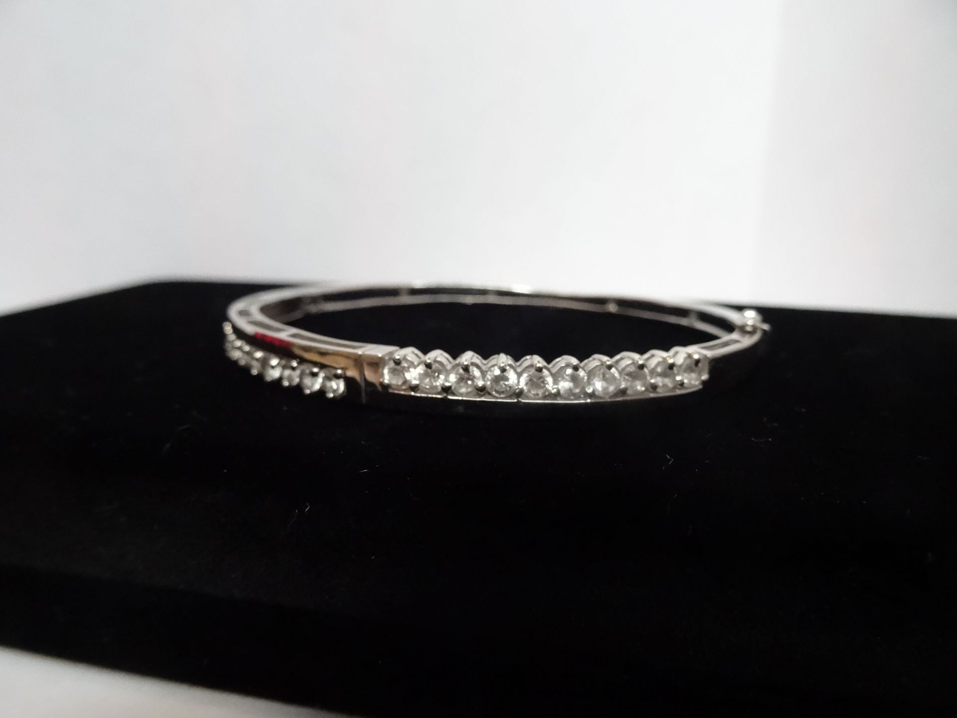 9 Carat White Gold Clear Stone Hinged Bangle. Contains 20 x 2.75mm Clear Stones.