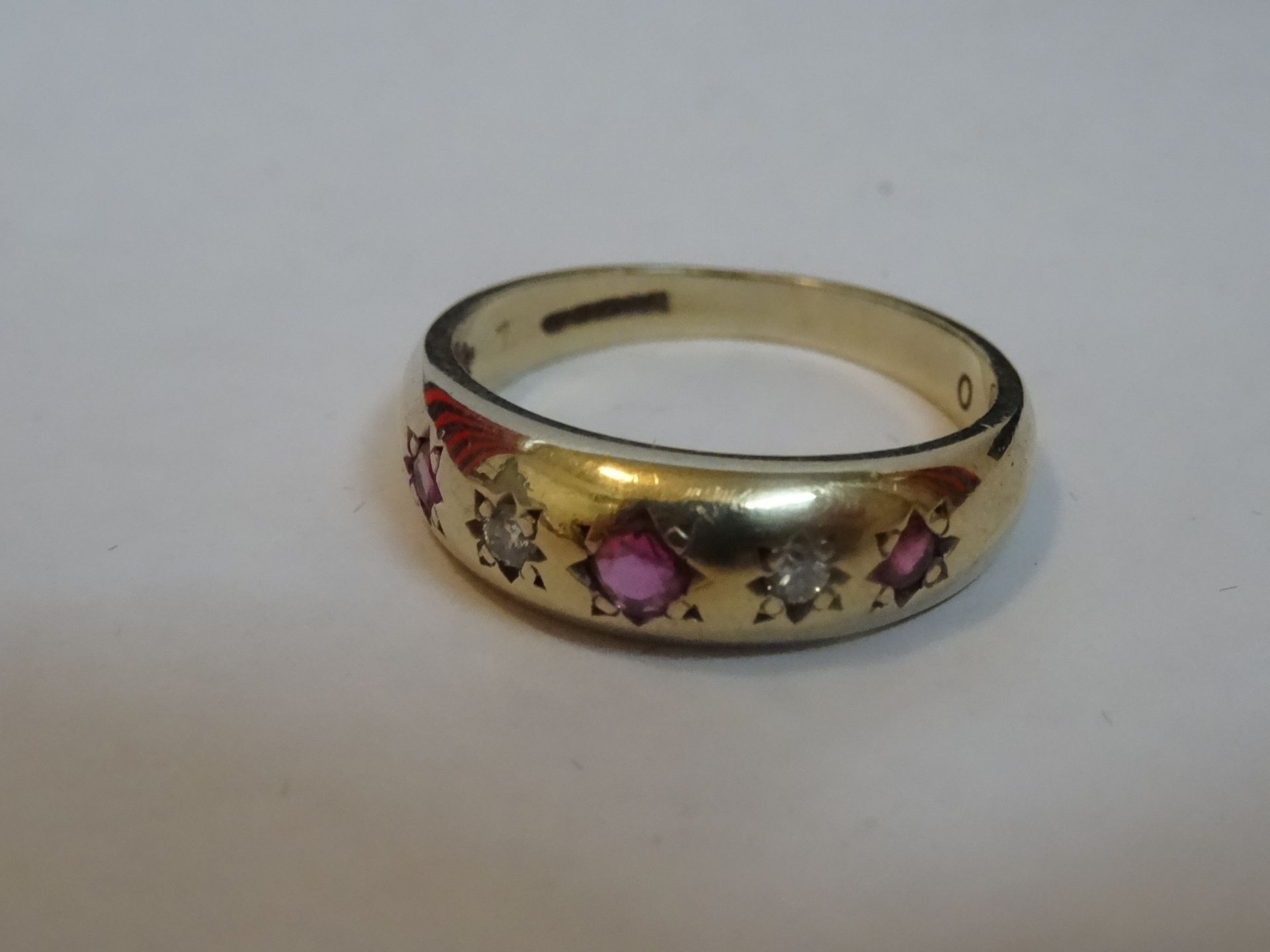 9 Carat Yellow Gold Diamond & Red Stone Ring. Total Piece Weight: 3.11 Grams