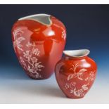 Hutschenreuther, zwei Vasen, wohl 1950er Jahre, weiße Bemalung auf rotem Fond. H. ca. 22cm u. ca. 16