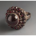 Ring mit Granaten, Fassung Silber 800, mit 1 gr. runden Granatcabochon und 34 Granatrosen.Ca. 15,2