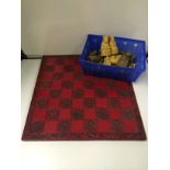 Vintage soapstone chess pieces on a red board :