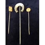 Three stick pins, two gold with seed pearls and one silver horseshoe