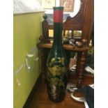 A large hand painted wine bottle with floral design