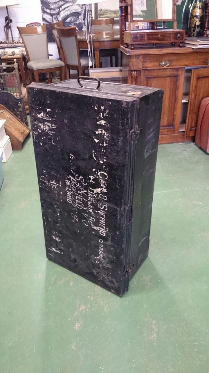 A large black heavy duty tin trunk.