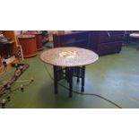 Ornate round brass Arabian coffee table approx 4' in dimeter with a dark carved six leg stand