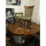 A circular dining table with six chairs and additional central leaf.