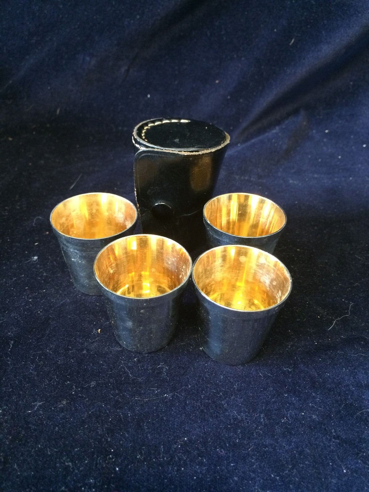 Set of four silver shot glasses in a leather travel case