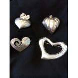 Four silver heart pendants and broaches.