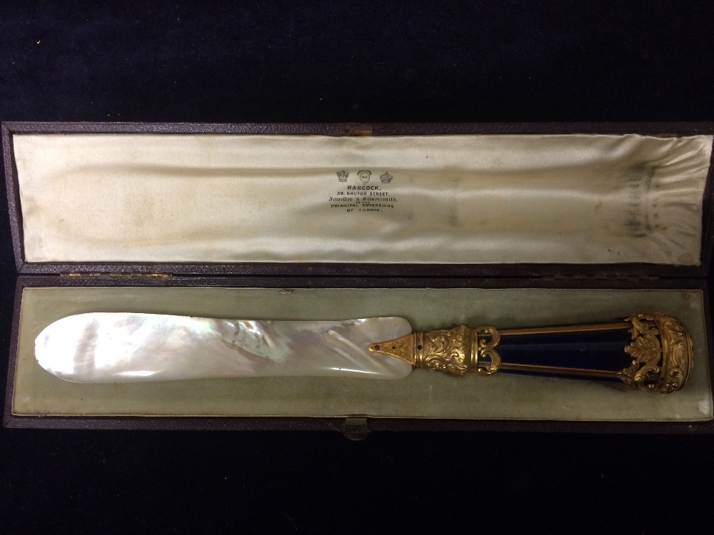 A mother pearl letter opener with gilt handle by Hancock of 39 Bruton Street.