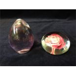 Two paperweights encased glass rose and a clear and pink encased
