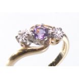 A 9ct gold gem set crossover ring
The central round cut amethyst flanked by two tiny illusion set