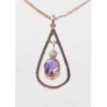 An early 20th Century amethyst and seed pearl set pendant
Of typical open work tear drop form, to