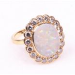 An 18ct gold opal and diamond set cluster ring
The oval cabochon opal of approx 15x12cm, collet set