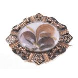 A Victorian mourning brooch 
The central oval window displaying hair, wire and bead work, to a