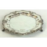 A hallmarked silver card tray
Of shaped circular form, having cast scrolling and open shell rim,