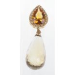 A citrine and yellow sapphire set pendant
The pear cut citrine within a border of yellow sapphires