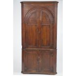 An 18th Century and later oak free standing corner wall cupboard
With a cavetto cornice above a