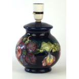 A Walter Moorcroft bulbous form lamp base
Decorated in the Clematis pattern on a blue and green