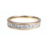 A 18ct gold diamond set half eternity ring
Channel set with nine princess cut diamonds to tapering