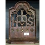 A 18th Century and later oak Religious hanging shelf entitled 'IHS' having brass applied and poker