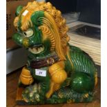 A reproduction oriental dog of foe modelled in a green and yellow glaze.